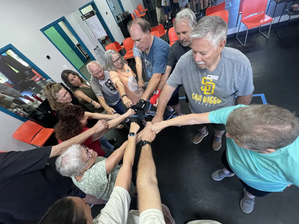 Rock Steady Boxing members in a team huddle at Wise Owl Fit